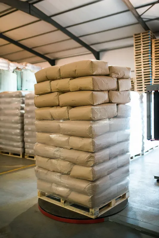 Verzegelde zakken rooibos, gestapeld op een pallet in het magazijn.